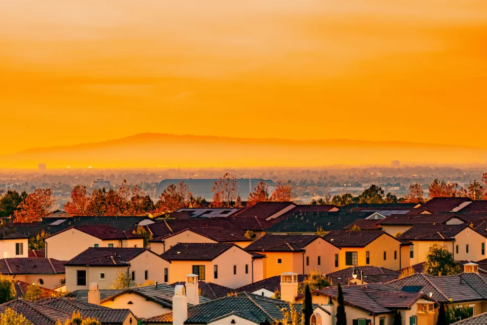 View of Spanish-style homes in dense neighborhood in Orange County, California at sunset.